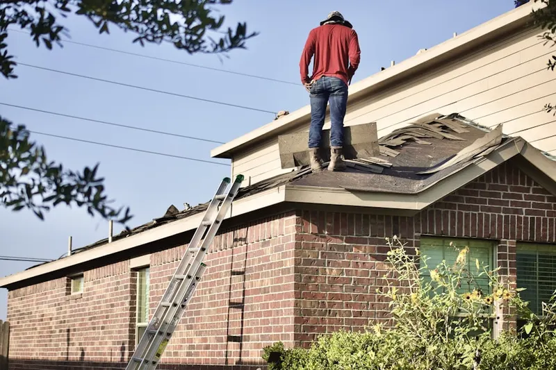 Professional roofer working on a residential roof in Stonewall Orchard
